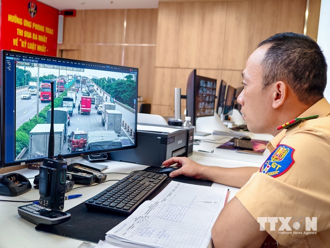Cán bộ Đội Chỉ huy giao thông và điều khiển đèn tín hiệu giao thông theo dõi tình hình phương tiện qua hệ thống camera tại khu vực cầu Thanh Trì. (Ảnh: Trung Nguyên/TTXVN)